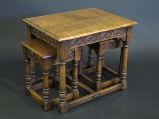 A nest of 3 carved oak interfitting coffee tables, raised on turned and block supports 23"