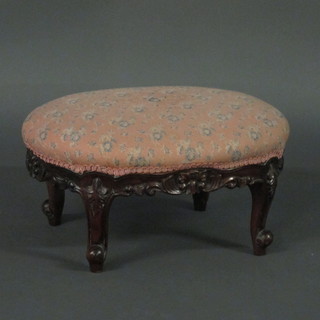 A Victorian style oval carved footstool with upholstered seat  raised on cabriole supports 19"