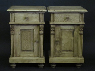 A pair of pine bedside cabinets fitted a drawer above a cupboard  and raised on bun feet 17"