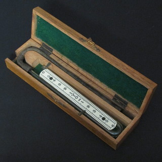 A precision instrument comprising shaped glass tube contained  in an oak case with hinged lid