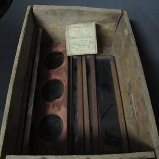 A wooden box containing various magic lantern slides