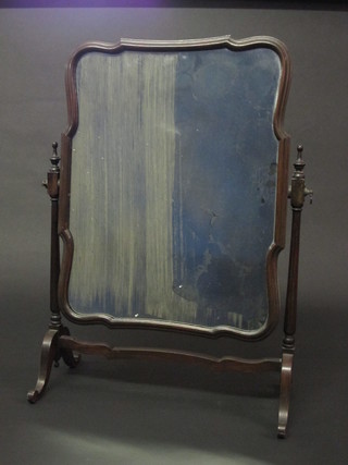 A shaped dressing table mirror contained in a mahogany swing  frame
