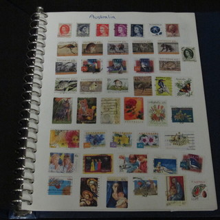 A blue plastic loose leaf album of stamps