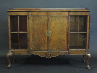 A Waring & Gillow Queen Anne style walnut bow front display  cabinet with three-quarter gallery, fitted a cupboard enclosed by a  panelled door, flanked by a pair of cupboards enclosed by  astragal glazed panels, raised on cabriole supports, 52"