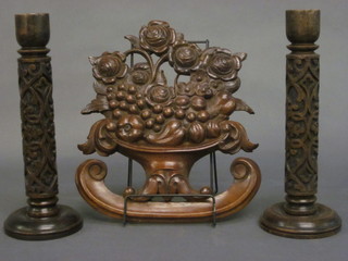 A pair of turned hardwood candlesticks 13" and a carved wooden plaque in the form of a basket of fruit 12"