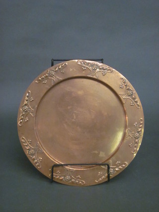 An Art Nouveau circular embossed copper bread board holder  12"