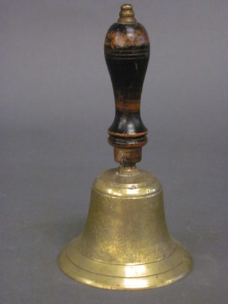 A brass bell with turned handled