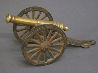 A model of a cannon with 5" brass barrel raised on an iron  carriage