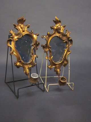 A pair of mirrored wall light sconces in gilt frames