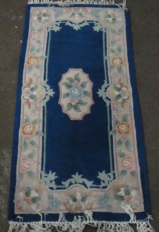 A Chinese blue ground and floral patterned rug 60" x 28"