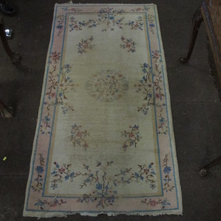 A 1930's white ground and floral patterned Chinese rug 77" x  37", heavily worn