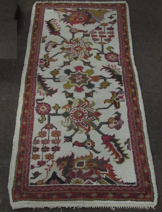 A Caucasian style white ground rug with stylised flowers to the  centre 72" x 36"