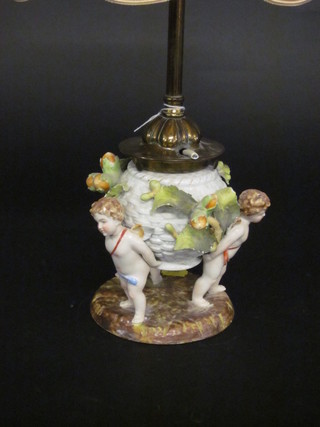 A globular circular shaped Continental porcelain oil lamp base supported by cherubs, converted to an electric table lamp 6"