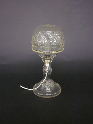 A circular cut glass table lamp raised on a spreading foot 14"