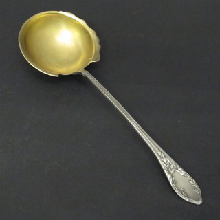 A Continental white metal ladle with gilt bowl