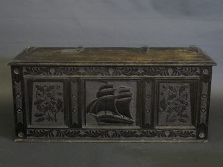 A dark oak coffer of panelled construction with hinged lid,  carved a galleon in full sail 47"