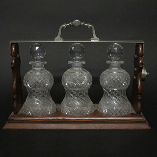 A Betjeman oak and cut glass 3 bottle tantalus with thistle shaped bottles, 1 bottle cracked, tantalus locked - no key,   ILLUSTRATED
