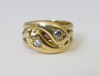 An 18ct gold dress ring in the form of two entwined serpents the eyes set diamonds