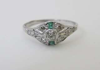 A lady's 18ct white gold dress ring set 2 rectangular cut emeralds supported by diamonds