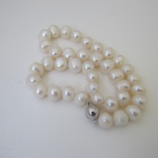 A rope of white pearls with silver clasp