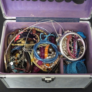 A metal box containing a collection of costume jewellery