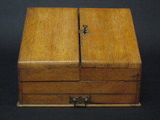 A Victorian honey oak stationery box with hinged lid revealing a well fitted interior, the base fitted a drawer, 14"