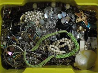 A yellow plastic crate containing a collection of costume  jewellery