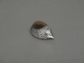 A white metal pin cushion in the form of a hedgehog, 2", base bears marks