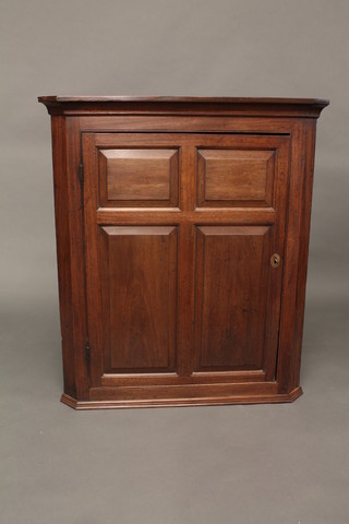 A 19th Century mahogany hanging corner cabinet with moulded  cornice, the interior fitted shelves enclosed by a panelled door