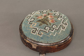 A circular Victorian mahogany footstool with beadwork seat,  raised on 3 bun feet 10"