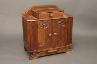 An Art Deco Continental carved oak cabinet fitted a drawer  above double cupboards 26"