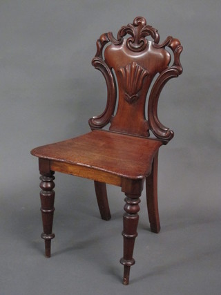A Victorian carved mahogany shield back hall chair with solid seat, raised on turned supports
