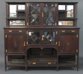 A Victorian aesthetic movement sideboard with raised back fitted cupboards enclosed by glazed doors and niches, the base fitted a  cupboard enclosed by bevelled plate panelled doors 70"