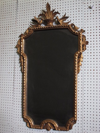 A shaped plate mirror contained in a decorative frame surmounted by an urn 33"