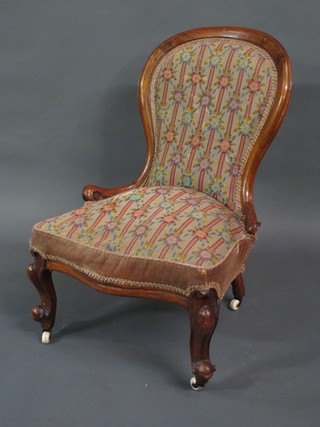 A Victorian walnut showframe nursing chair with upholstered  seat raised on cabriole supports