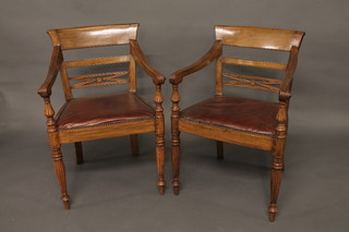 A pair of 19th Century mahogany bar back open arm carver  chairs with upholstered seats, raised on turned supports