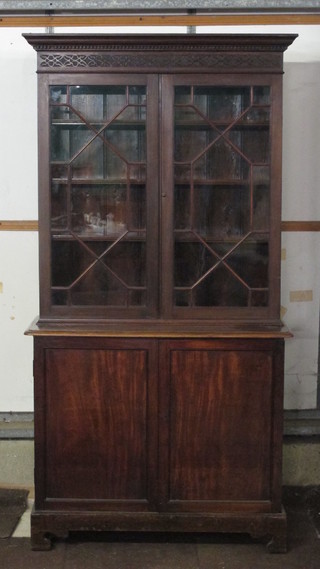 A Georgian mahogany display cabinet on cabinet with associated top with moulded and dentil cornice, the shelved interior  enclosed by astragal glazed doors, the base fitted a cupboard  enclosed by panelled doors, raised on bracket feet 41"