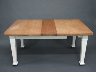 An Edwardian rectangular bleached oak dining table, raised on a white painted base with square tapering supports 60"