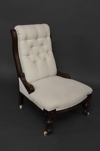 A Victorian oak show frame nursing chair upholstered in white buttoned back material