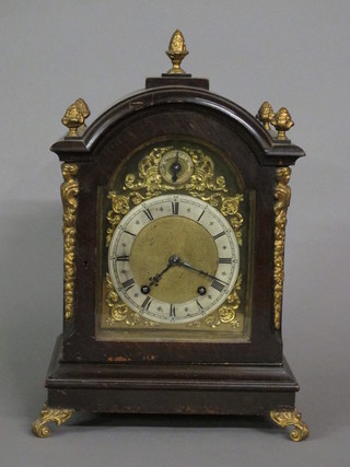 A 19th Century 8 day striking bracket clock with 6 1/2" brass arched dial with silver chapter ring, contained in an arched  mahogany case surmounted by urns  ILLUSTRATED