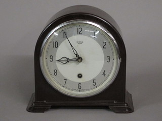 An Art Deco Smiths mantel clock with silvered dial and Arabic numerals contained in an arched brown Bakelite case