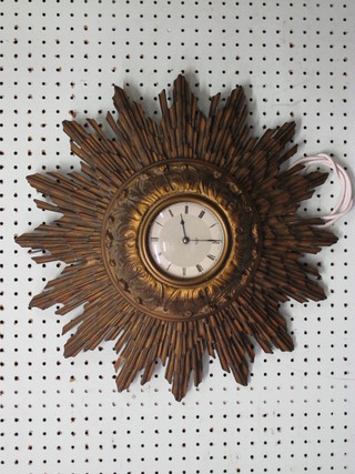 A Smiths Art Deco electric clock with silvered dial and Arabic numerals contained in a carved wooden sunburst case 18"
