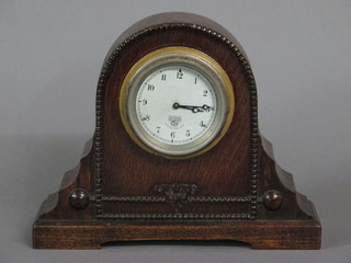 A Smiths car clock with silvered dial and Arabic numerals  mounted in an oval oak case
