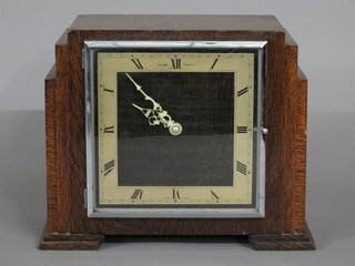 A Smiths Art Deco chiming electric mantel clock with square  dial and Roman numerals contained in an oak case