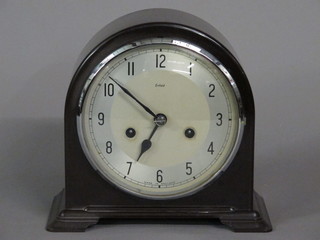An Art Deco mantel clock with silvered dial and Arabic numerals contained in a black arched Bakelite case by Enfield