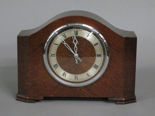 A 1950's striking electric with silvered dial and Roman numerals contained in an oak arch shaped case