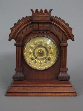 An Edwardian Continental 8 day striking clock with gilt dial and Arabic numerals contained in an oak arch shaped case