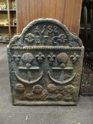 An iron arched fire back decorated 2 anchors and marked 1588  22"