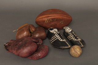 A pair of vintage running shoes, 2 pairs of leather boxing gloves,  a rugby ball and a base ball