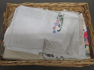 A rectangular wicker basket containing a collection of linens